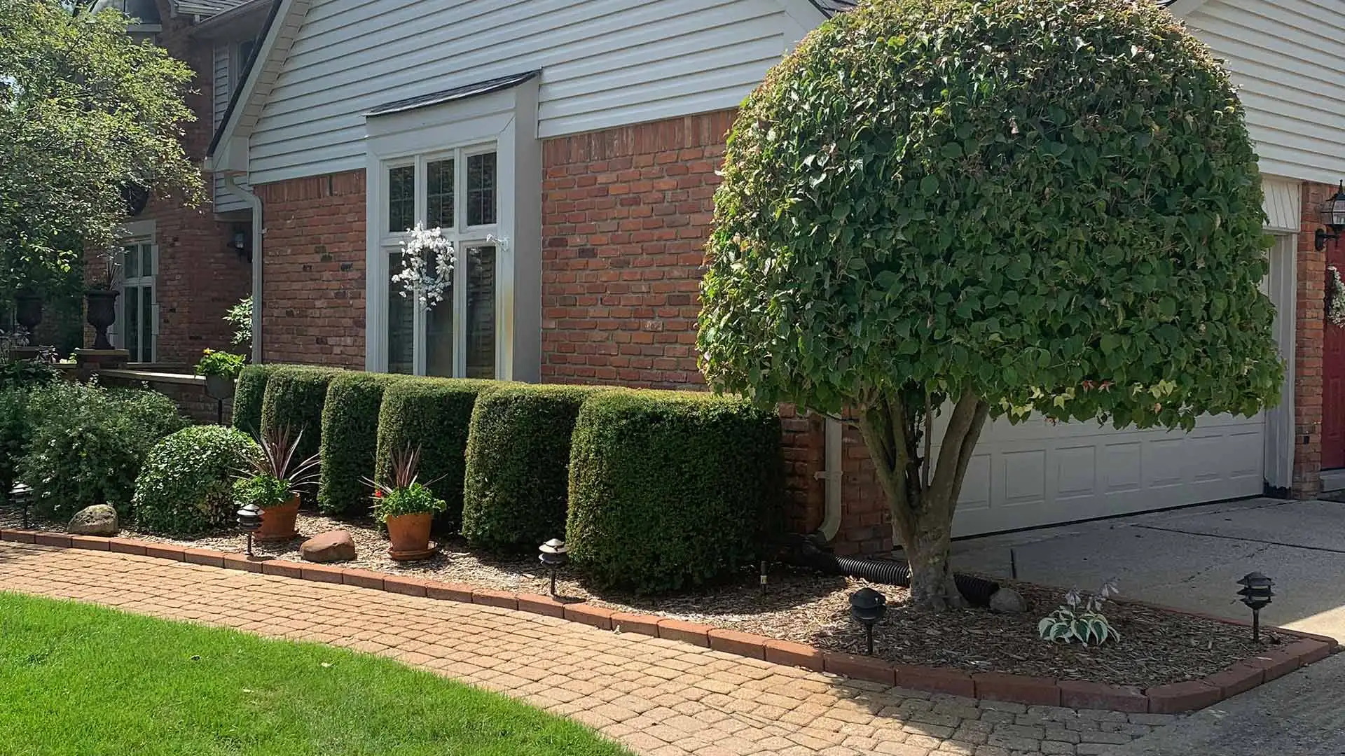 Home in Shelby, MI with landscape bed and trimmed shrubs.