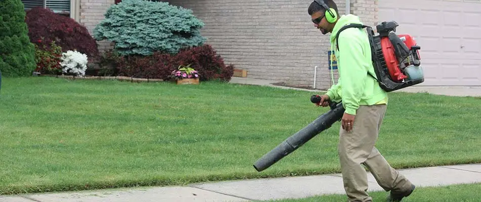 Big Lakes Lawncare lawn worker using a leaf blower in Chesterfield, MI.