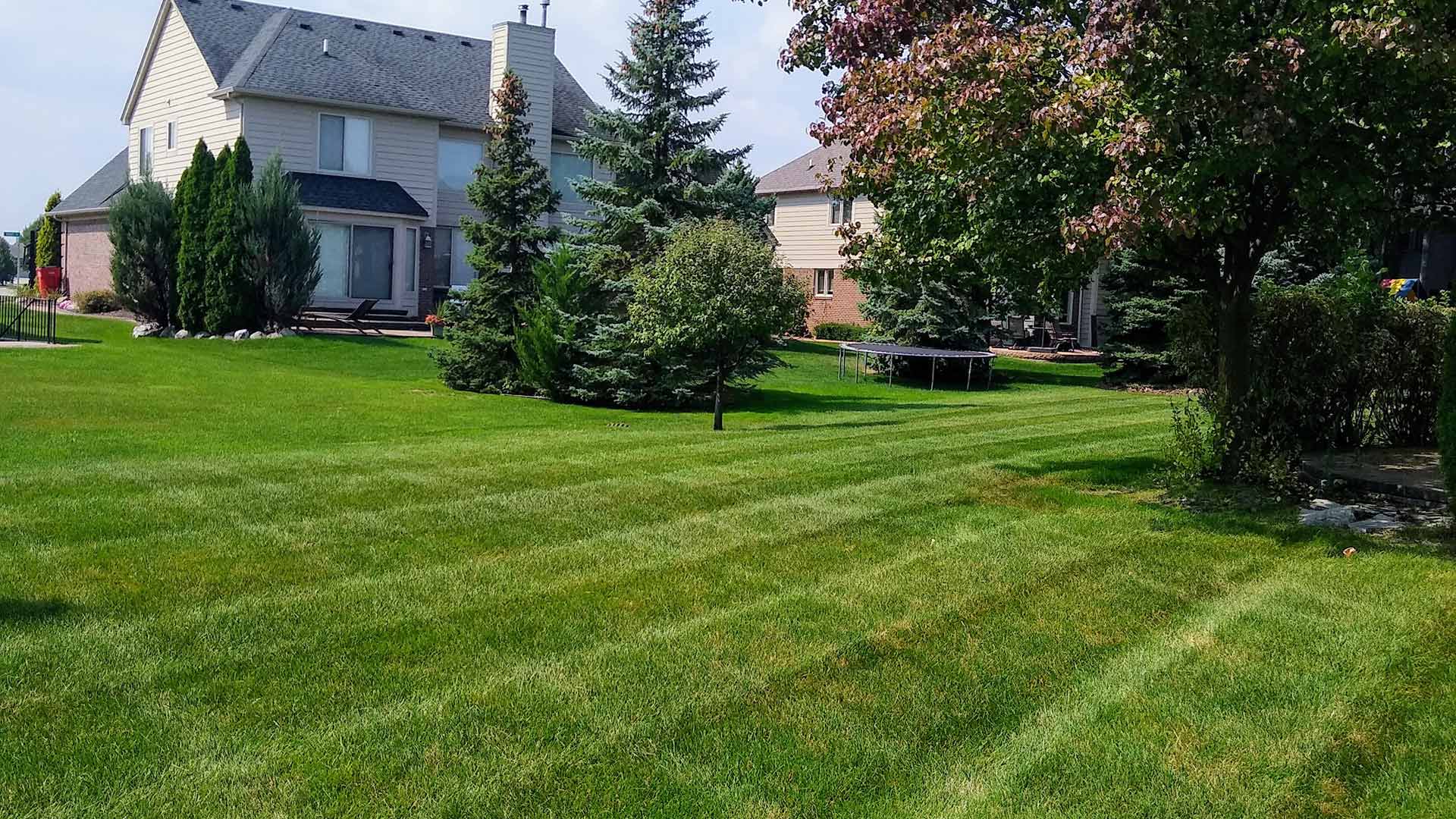 A Chesterfield, MI home with a healthy back yard showing mowing lines.