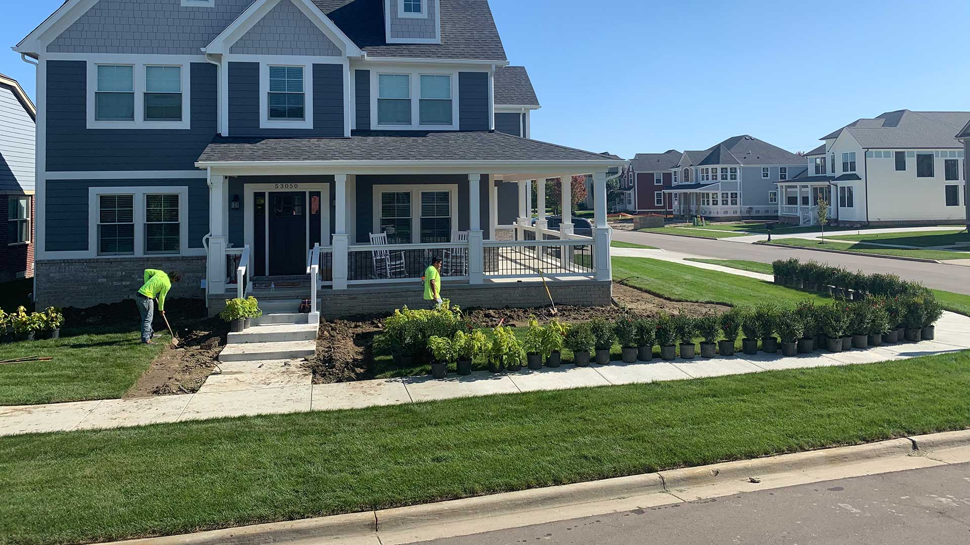 Landscape workers performing a bed renovation with plantings near Macomb, MI.