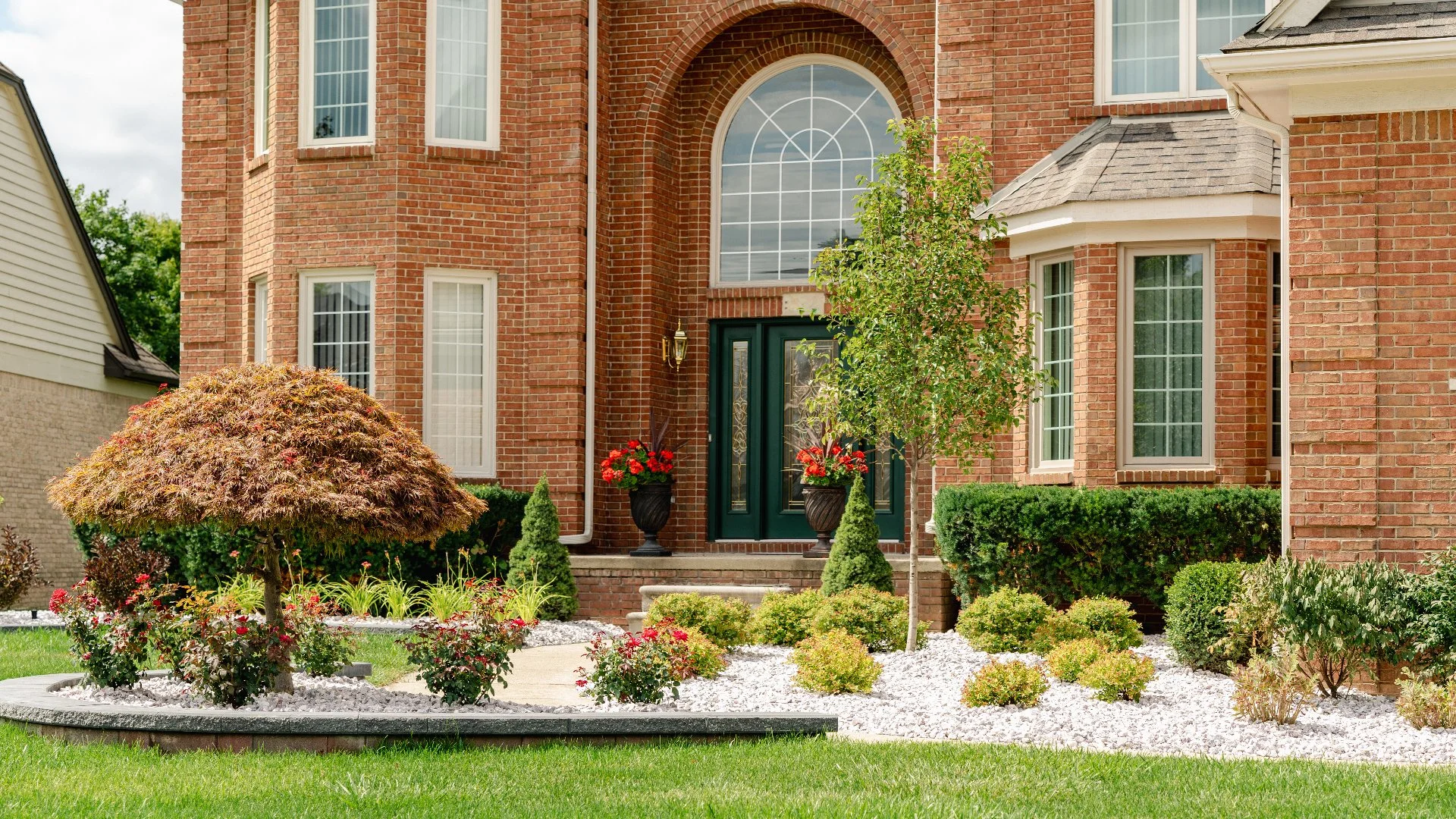 Home in Shelby, MI with trimmed shrubs and stones.