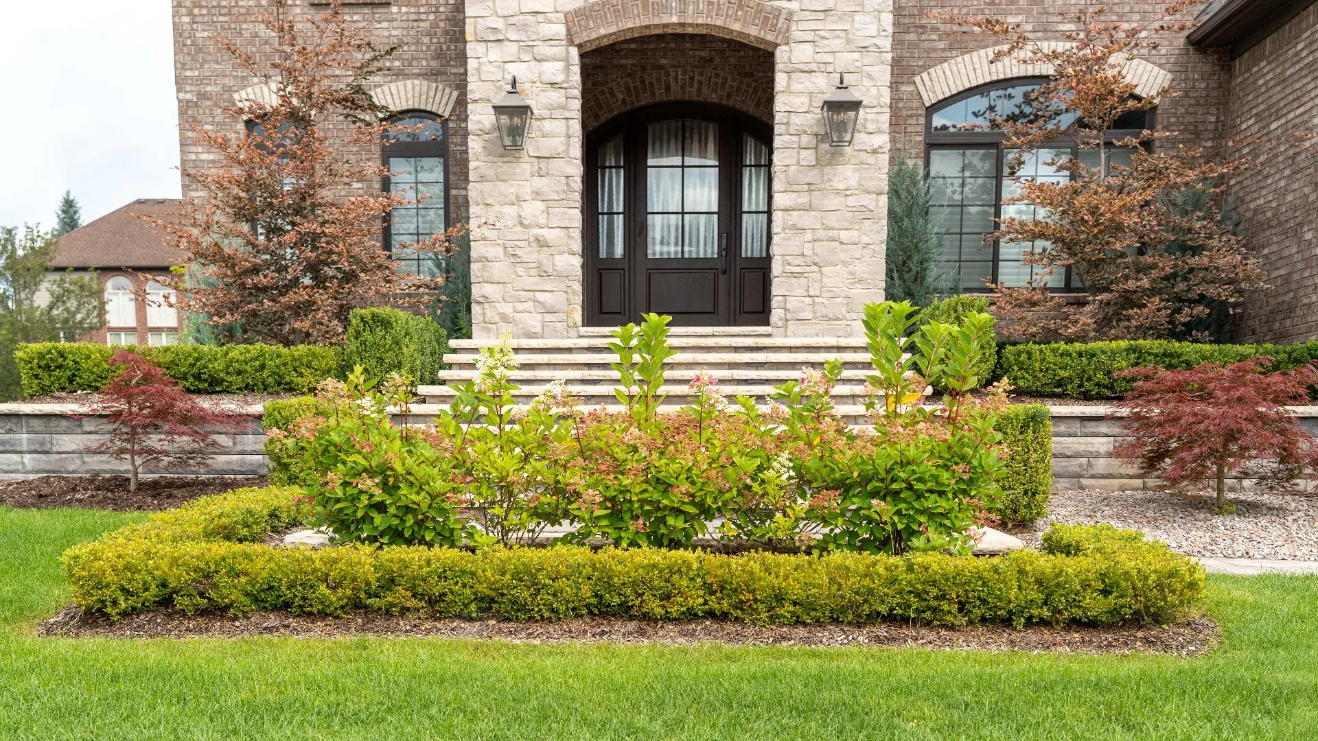 Elegant front yard with lush greenery and decorative shrubs at a Sterling Heights, MI home.