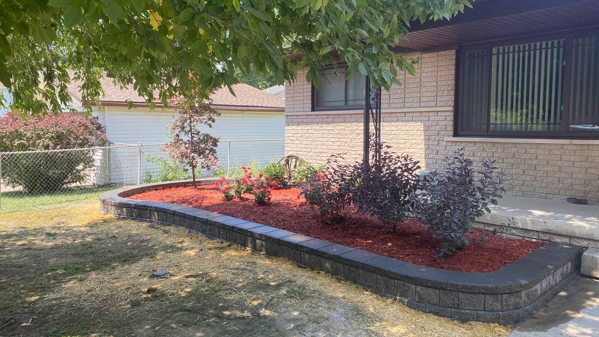 Landscape bed with mulch and retaining wall built in Waldenburg, MI.