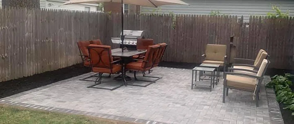 Completed paver patio design and dark mulch landscaping bed at a home in Macomb, MI.