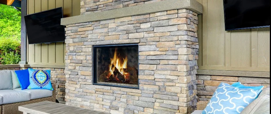 Stone outdoor fireplace in Macomb, MI, with seating. 