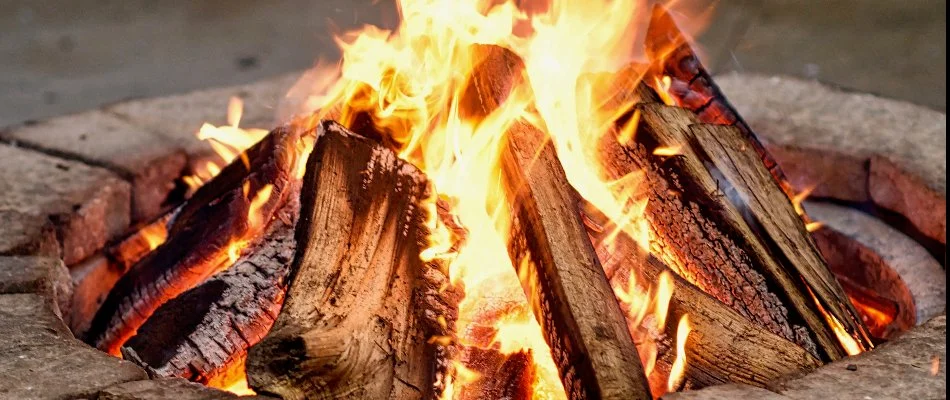 A circular fire pit burning wood in Macomb, MI.