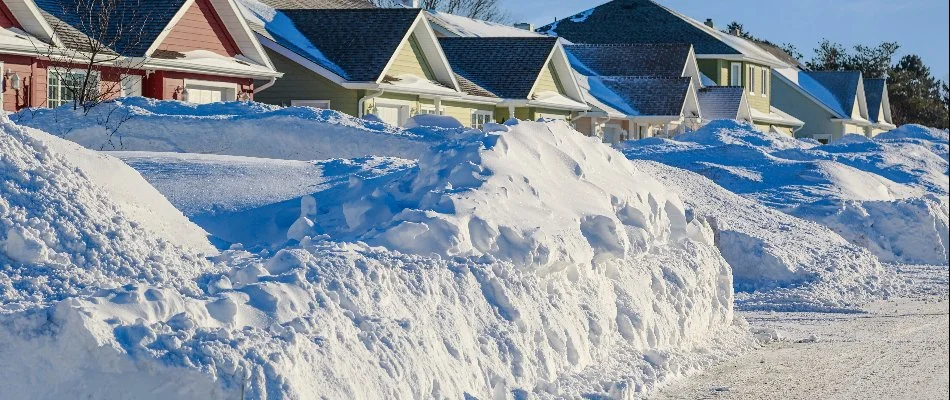 Houses in Macomb, MI, with thick snow pile.