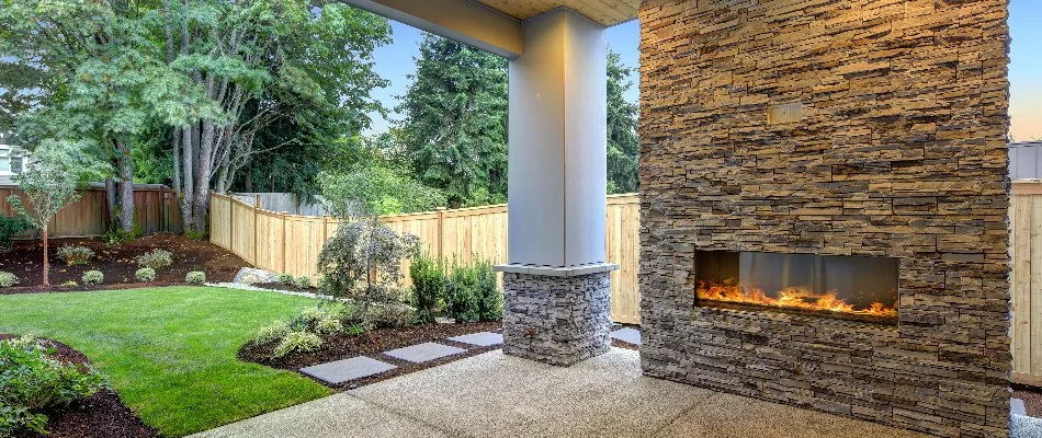 Large, stone outdoor fireplace in Macomb, MI, and landscaping.