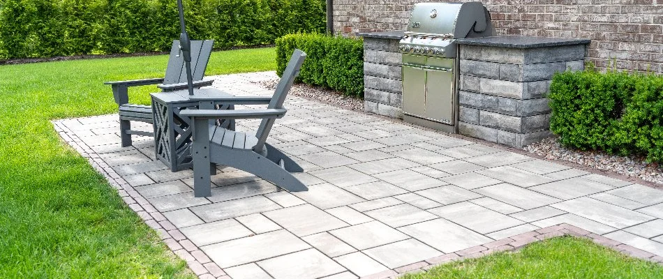 Paver patio in Macomb, MI, with chairs and an outdoor kitchen.