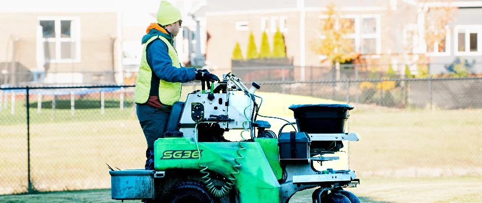 Lawn care professional on a granular fertilizer spreader machine in Macomb, MI.