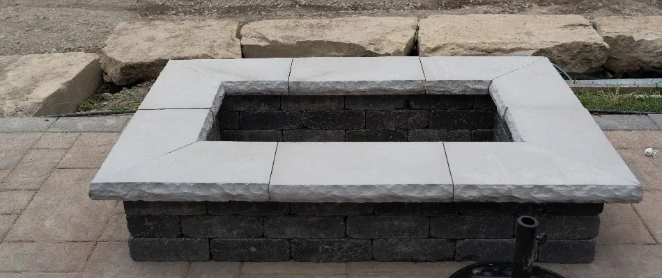 A rectangular fire pit in Macomb, MI, made of blocks and stone.