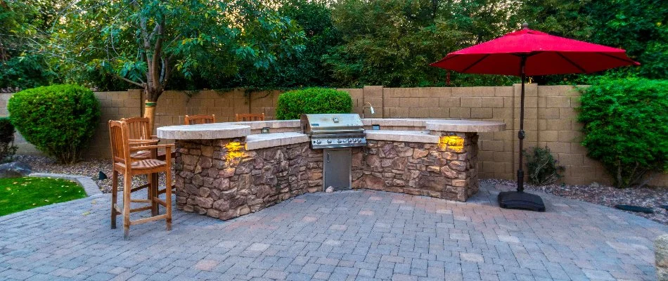 Stone outdoor kitchen and a red umbrella in Macomb, MI.