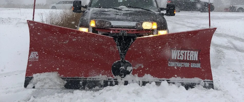 Truck in Macomb, MI, with a red snow plow and snow.