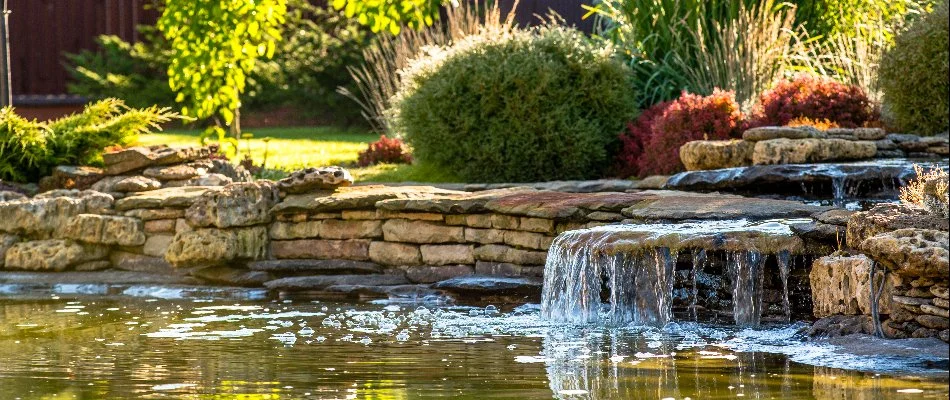 Waterfall with lush green shrubs in an outdoor space in Macomb, MI.