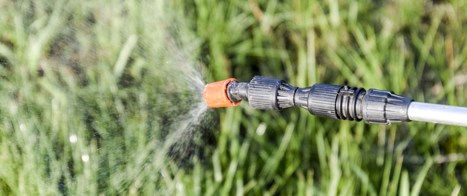 Fertilizer treatment sprayed from nozzle onto grass in Macomb, MI. 