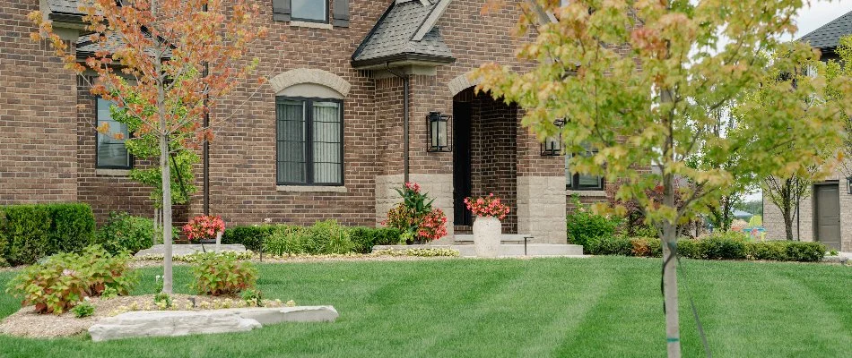 Front yard in Lathrup Village, MI, with flowers, shrubs, and a green lawn.