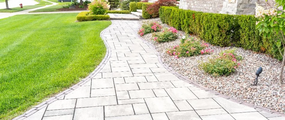 Modern paver walkway in Berkley, MI, between a lawn and landscape.