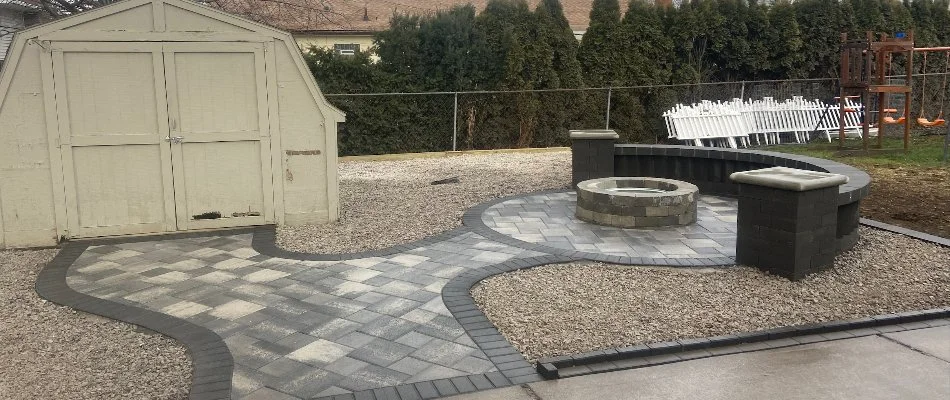 Patio area with a fire pit and seating wall in Oak Park, MI.