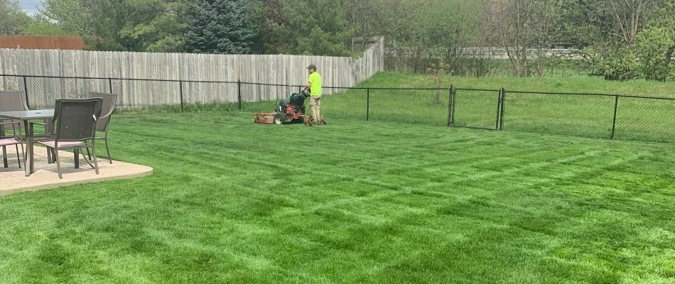 Professional from Big Lakes mowing backyard for clients in Harrison Township, MI.