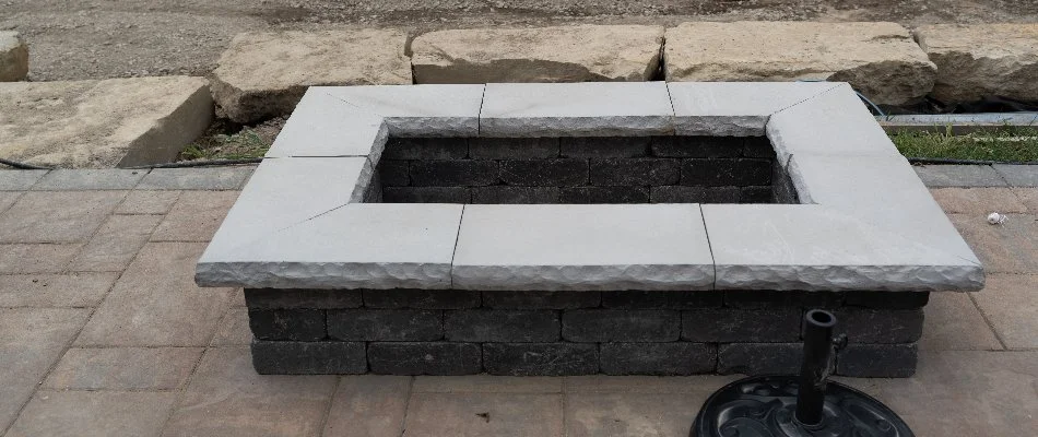 Rectangular fire pit in Lathrup Village, MI, with stone ledging.