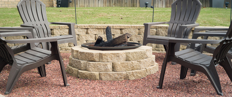 Wood burning fire pit beside a seating wall installed in Rochester, MI.